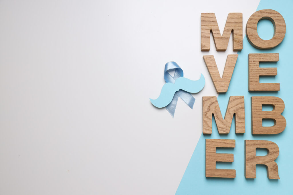 The inscription "Movember" in wooden letters with a mustache