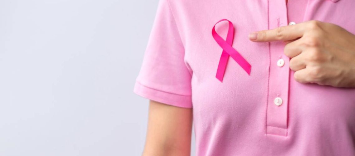 Pink October Breast Cancer Awareness month, woman hand hold pink Ribbon and wear shirt for support people life and illness. National cancer survivors month, Mother and World cancer day concept